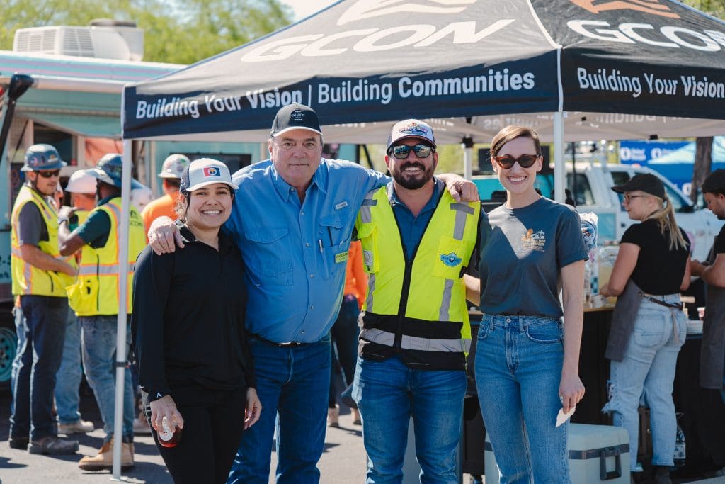 Four GCON team members smiling under a GCON tent during Construction Safety Week 2025 event.